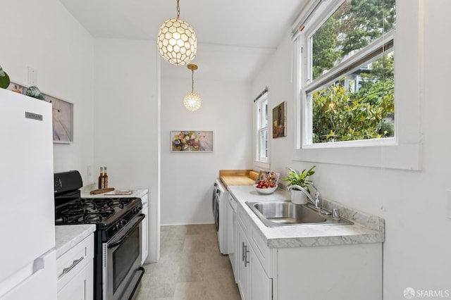 1250 Vallejo St Unit 2, San Francisco, CA 94109 - kitchen featuring stainless steel gas stove, freestanding refrigerator, light countertops, white cabinets, and decorative light fixtures