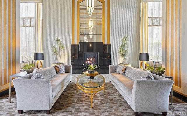 living area featuring plenty of natural light, a warm lit fireplace, and wallpapered walls