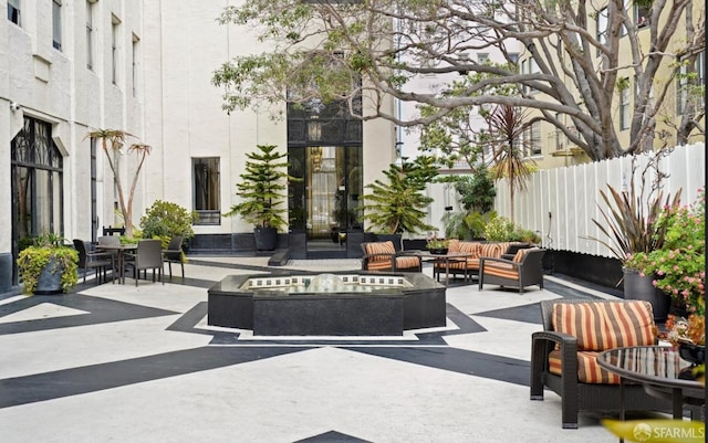 view of patio featuring an outdoor living space with a fire pit and fence