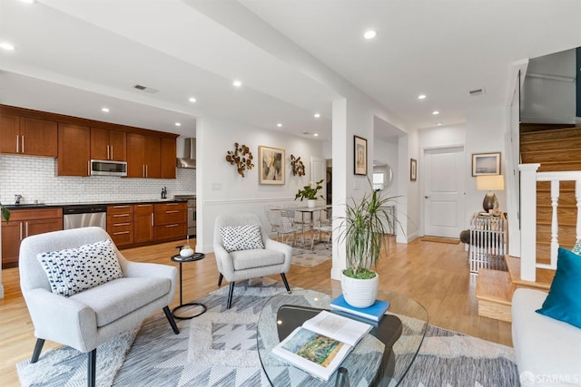 living area featuring stairway, light wood-type flooring, visible vents, and recessed lighting