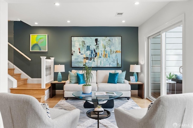 living area featuring light wood-style floors, stairway, visible vents, and recessed lighting