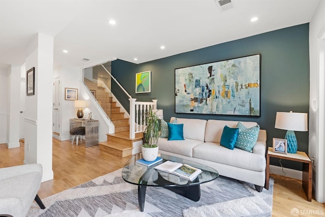 living area featuring light wood-style flooring, stairs, visible vents, and recessed lighting