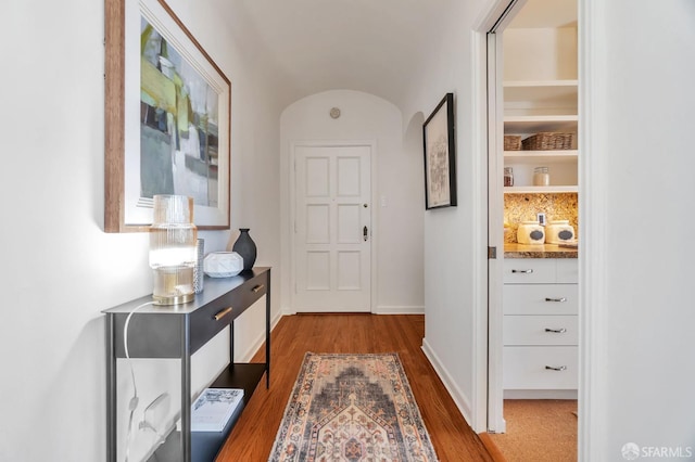 hall featuring baseboards and dark wood finished floors