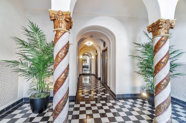 corridor with arched walkways and baseboards