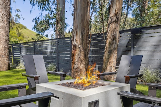 view of community featuring fence and an outdoor fire pit