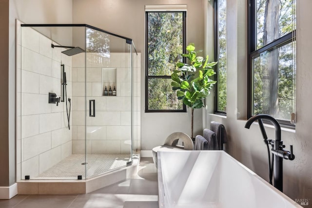 full bath with a soaking tub, tile patterned floors, a sink, and a shower stall