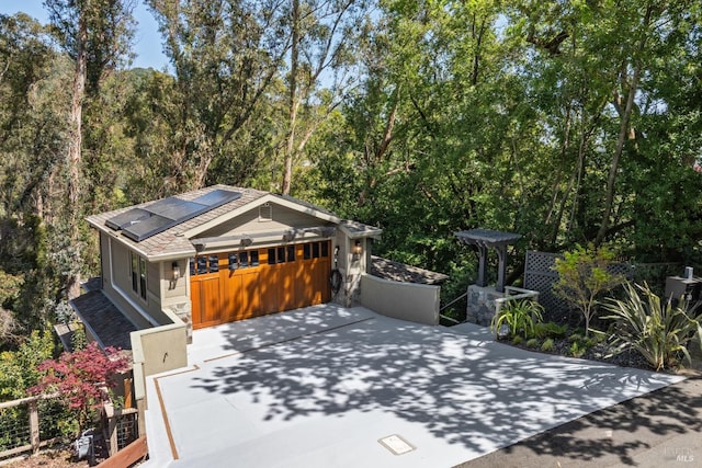 view of front of home with solar panels and concrete driveway