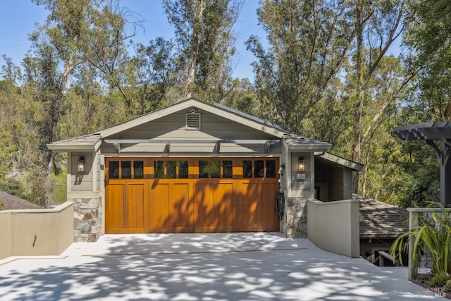view of front facade with driveway, stone siding, and a garage