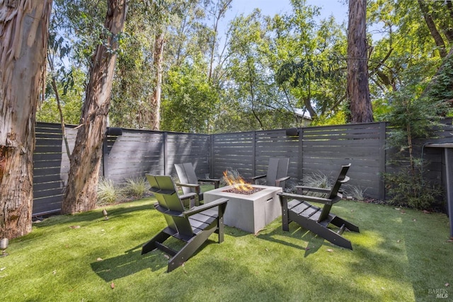 view of yard featuring a fenced backyard and a fire pit