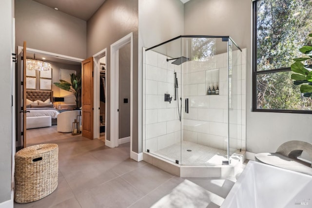 bathroom with a shower stall, a wealth of natural light, tile patterned flooring, and ensuite bathroom