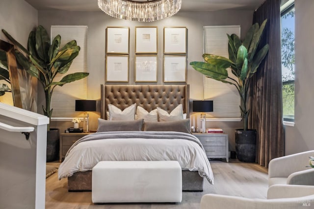 bedroom featuring wood finished floors, a chandelier, and multiple windows