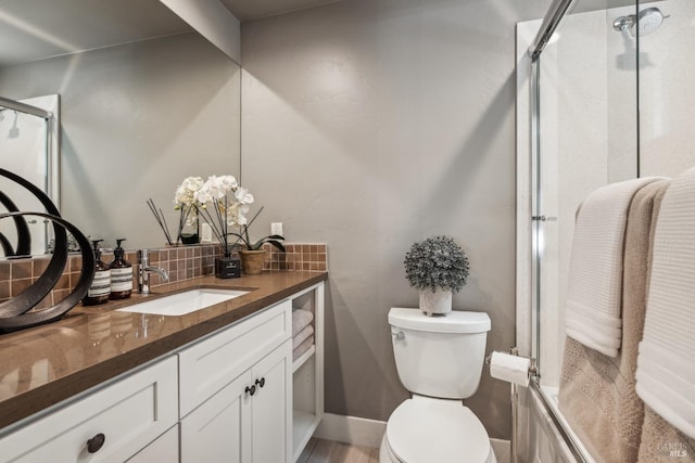 full bath featuring a shower with door, vanity, and decorative backsplash