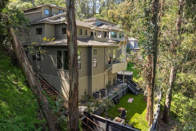 view of side of home featuring stairway, a lawn, fence, and central air condition unit
