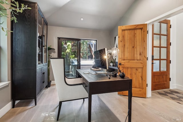 office featuring vaulted ceiling, light wood finished floors, and baseboards