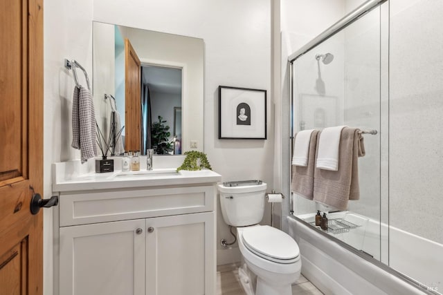 full bath with toilet, vanity, and enclosed tub / shower combo