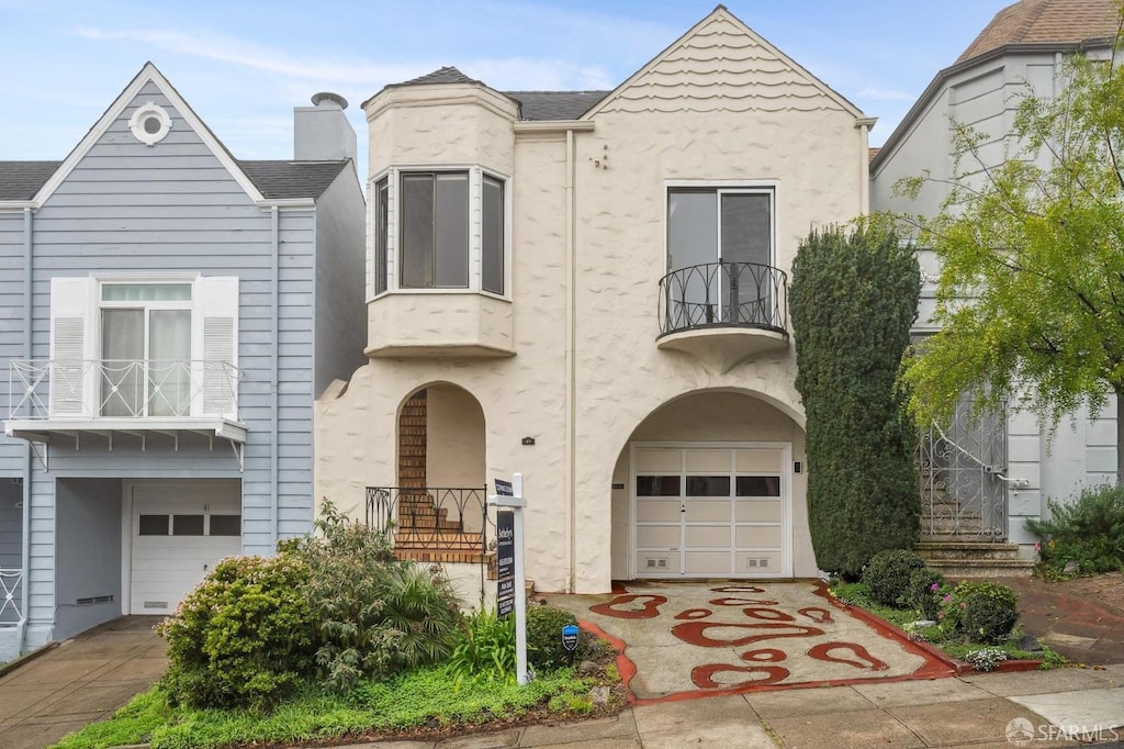 view of front of home with a garage and a balcony