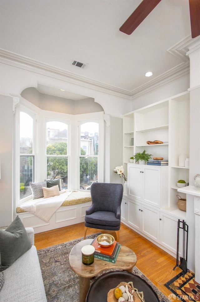 living area with light wood-style flooring, recessed lighting, visible vents, a ceiling fan, and crown molding