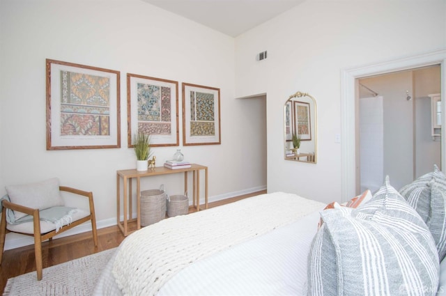 bedroom with visible vents, baseboards, and wood finished floors