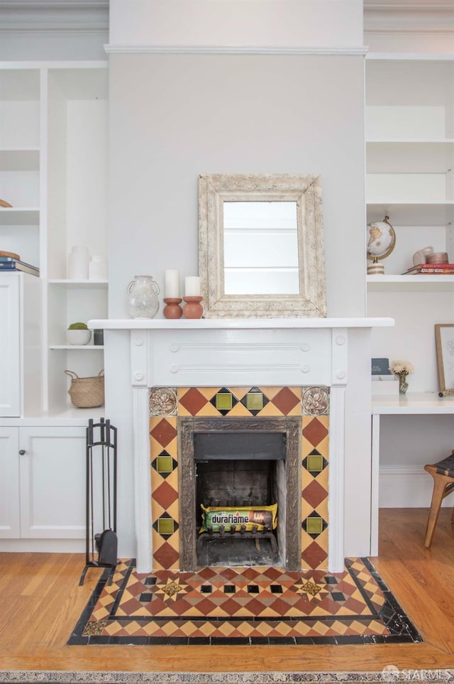 details featuring wood finished floors and a tile fireplace