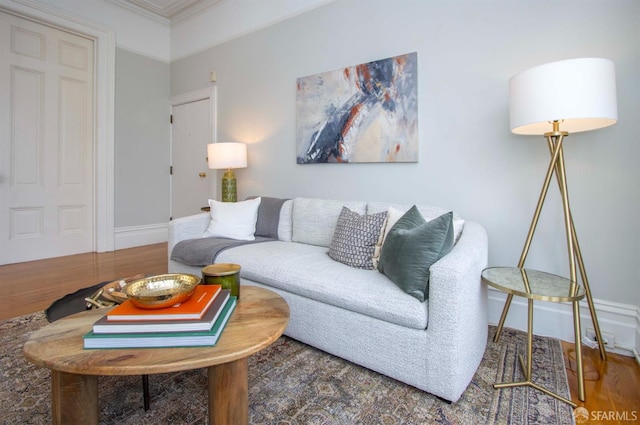 living area featuring ornamental molding, wood finished floors, and baseboards