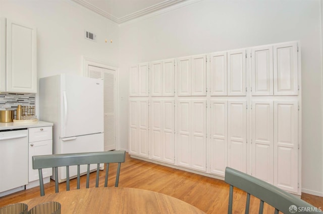 kitchen featuring white appliances, visible vents, white cabinets, decorative backsplash, and light countertops