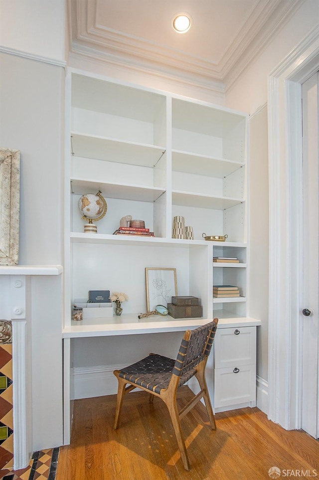 office space with ornamental molding, built in study area, and light wood-style floors