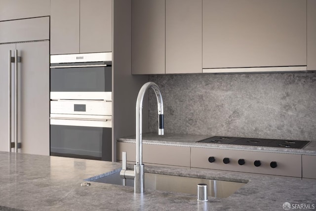 kitchen featuring tasteful backsplash, stainless steel double oven, sink, paneled built in fridge, and range hood