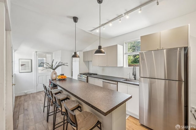 411 Clipper St, San Francisco, CA 94114 - kitchen featuring stainless steel appliances, dark countertops, a sink, a center island, and a breakfast bar area