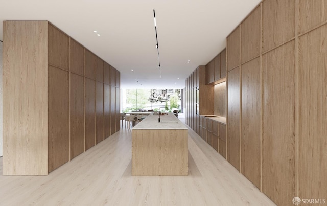 411 Clipper St, San Francisco, CA 94114 - kitchen featuring modern cabinets, light wood-style floors, a center island with sink, wood walls, and open floor plan
