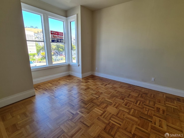 empty room with a healthy amount of sunlight and parquet floors