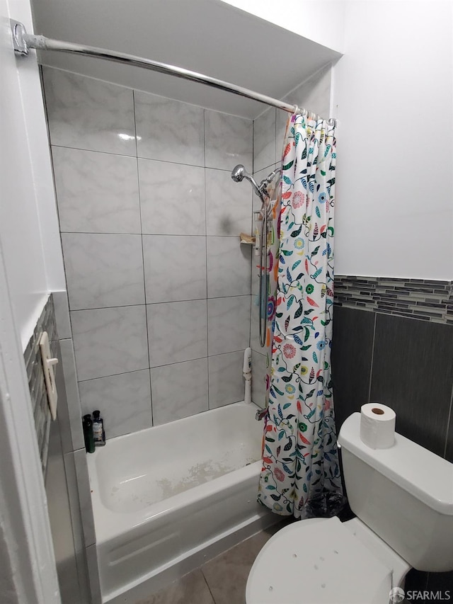 bathroom featuring a shower with shower curtain, tile patterned flooring, and toilet