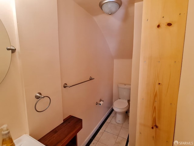 bathroom featuring toilet, tile patterned floors, and lofted ceiling