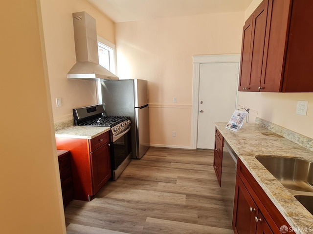 kitchen featuring light stone countertops, appliances with stainless steel finishes, extractor fan, sink, and light hardwood / wood-style floors