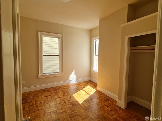 unfurnished bedroom with a closet and light parquet floors