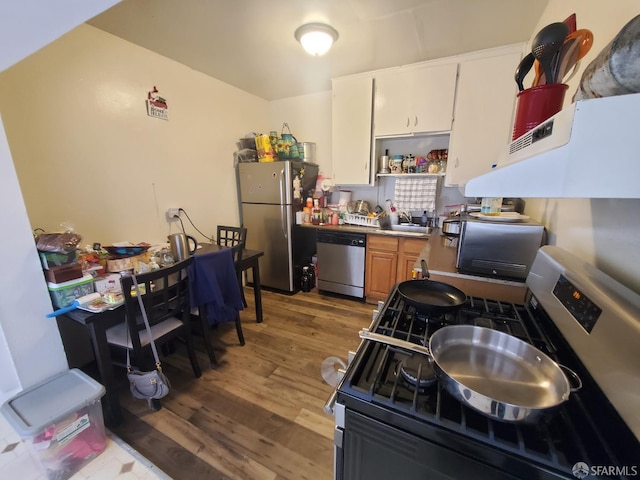 kitchen featuring white cabinets, appliances with stainless steel finishes, hardwood / wood-style flooring, and sink