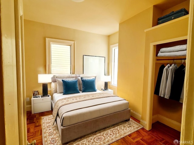 bedroom with dark parquet flooring and a closet