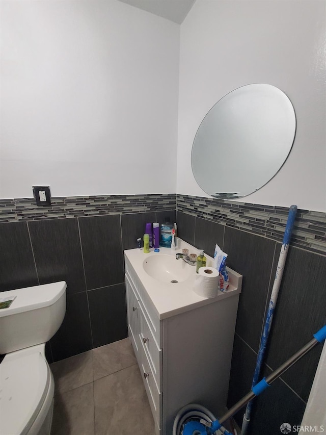 bathroom featuring tile patterned floors, vanity, tile walls, and toilet