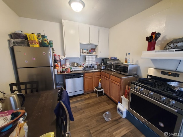 kitchen featuring dark wood-type flooring, white cabinets, sink, appliances with stainless steel finishes, and extractor fan