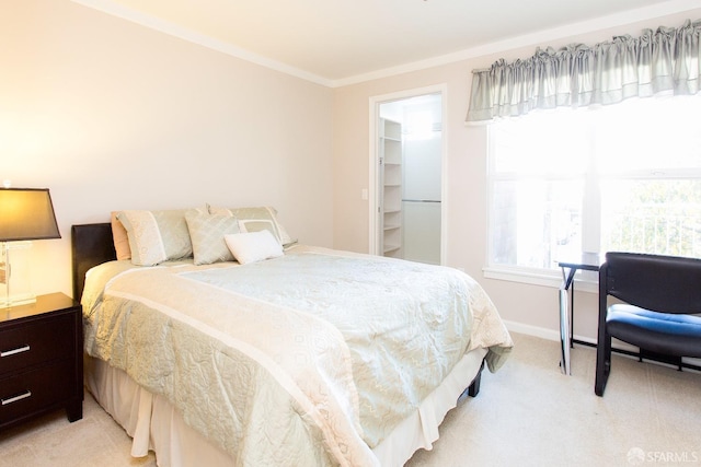 carpeted bedroom featuring ornamental molding and a spacious closet