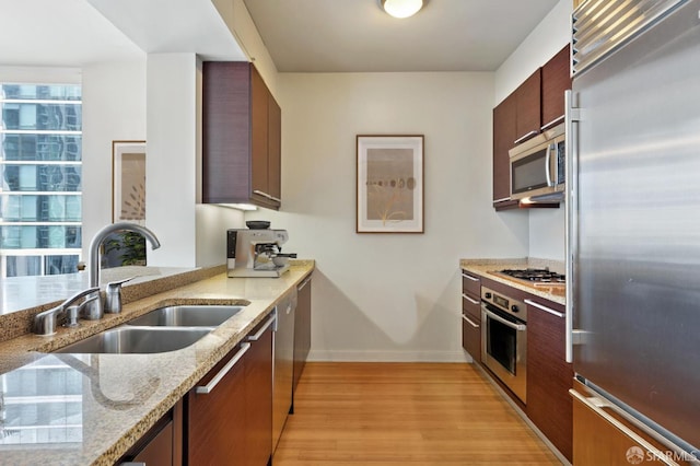 425 1st St Unit 2007, San Francisco, CA 95105 - kitchen featuring appliances with stainless steel finishes, light wood-style floors, light stone counters, and plenty of natural light