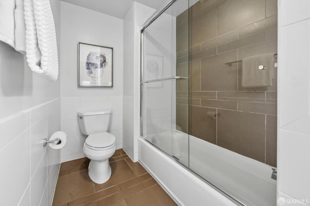555 4th St Unit 636, San Francisco, CA 94107 - bathroom with enclosed tub / shower combo, a wainscoted wall, tile patterned floors, and tile walls