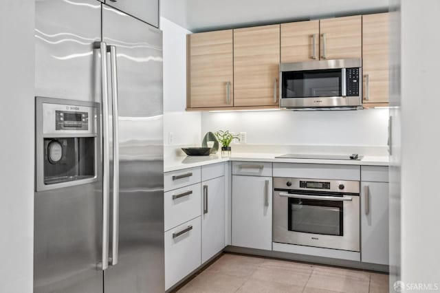 555 4th St Unit 636, San Francisco, CA 94107 - kitchen with appliances with stainless steel finishes, light countertops, light tile patterned floors, and light brown cabinetry