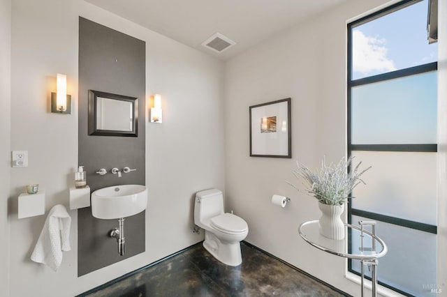 bathroom featuring visible vents, concrete flooring, and toilet