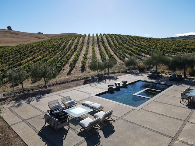 pool with a rural view and a patio