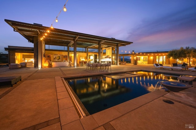 view of pool with a patio and a pool with connected hot tub