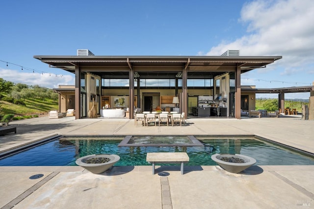 view of swimming pool with a patio and a pool with connected hot tub