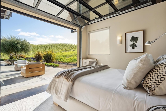 bedroom with finished concrete flooring, access to exterior, and multiple windows