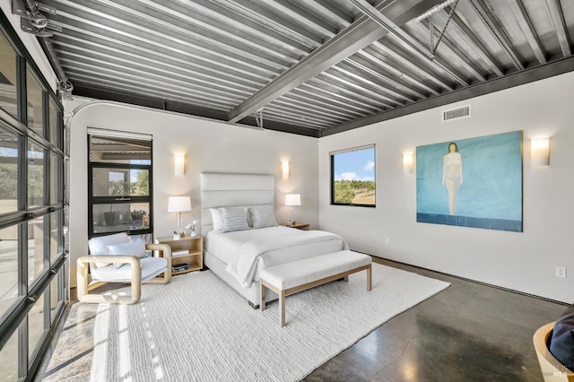 bedroom featuring visible vents, multiple windows, and finished concrete flooring