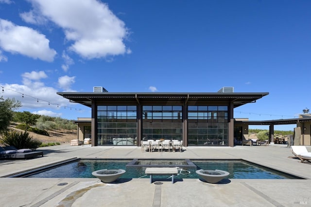 view of swimming pool featuring a patio area and a pool with connected hot tub
