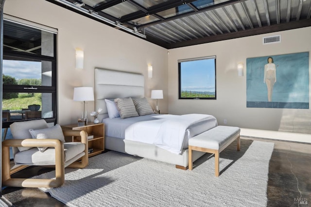 bedroom with finished concrete floors and visible vents